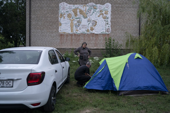A couple assembles a tent in an area on the roadside of a village about 30 kilometres from the Zaporizhzhia, where shelling has taken place. 