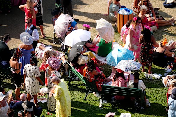 Racegoers sheltering from the warm weather under umbrellas at Royal Ascot on Thursday.