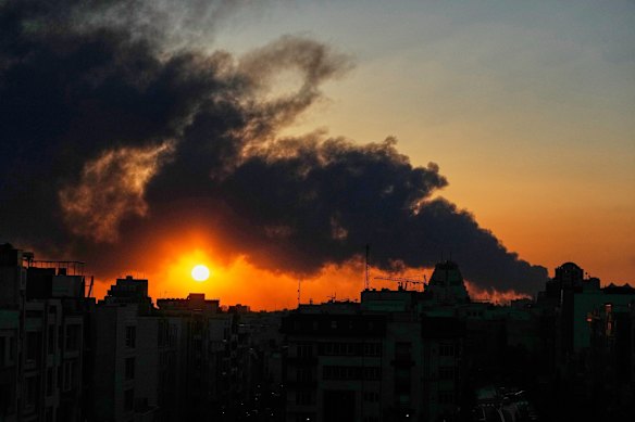 The sun sets behind a plume of smoke rising after a US-Israeli military strike in Tehran, Iran’s capital.  