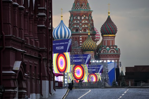 People make preparations for a concert at the Red Square, with constructions reading the words “Donetsk, Luhansk, Zaporizhzhia, Kherson, Russia”, and the St. Basil’s Cathedral and Lenin Mausoleum on the background, in Moscow.