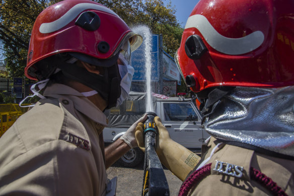 Indian firefighters disinfect a sealed area outside an Islamic seminary in the Nizamuddin neighbourhood of Delhi, after a 36-hour-long operation to evacuate 2631 Muslims to hospitals for quarantine earlier this month.
