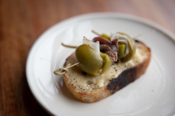 The gilda is threaded with lardo and served on fermented potato bread. 