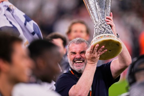 Tottenham’s head coach Ange Postecoglou holds up the trophy.
