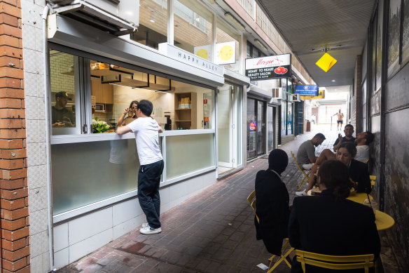 Small outdoor tables dot the laneway.