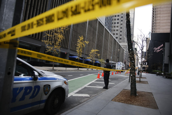 A New York police officer stands on 54th Street outside the Hilton Hotel in midtown Manhattan wher<em></em>e Brian Thompson, the CEO of UnitedHealthcare, was fatally shot.