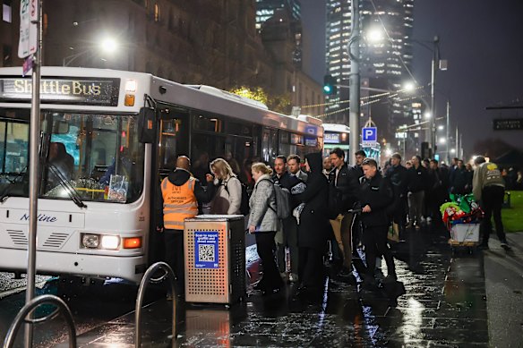 People queue for replacement buses at Spring St near Parliament station after trains on the Hurstbridge and Mernda lines are disrupted, due to a power fault in the Clifton Hill area.