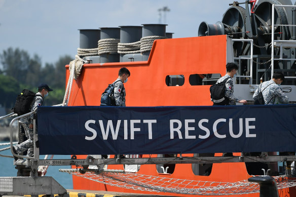 Crew board the MV Swift Rescue, a submarine support and rescue vessel, before being dispatched to Indonesia from Singapore.