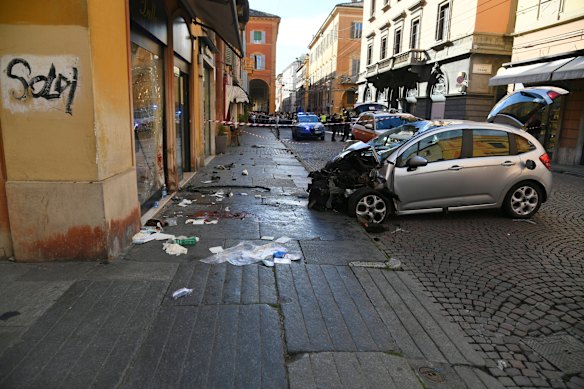 Si vede sangue accanto a un'auto distrutta in una strada di Modena, in Italia.