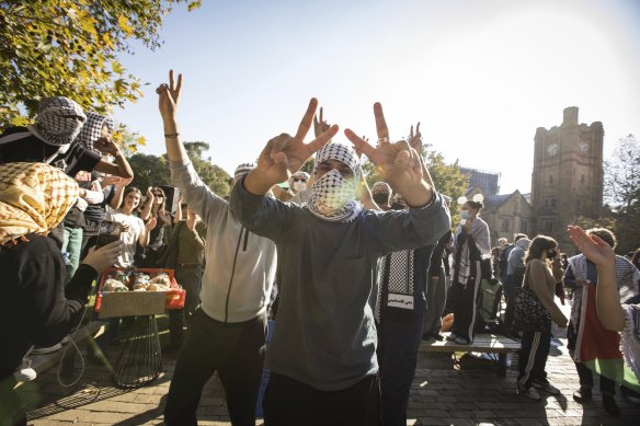 People dance at the pro-Palestine student protest as pro-Israel supporters encircle the camp.