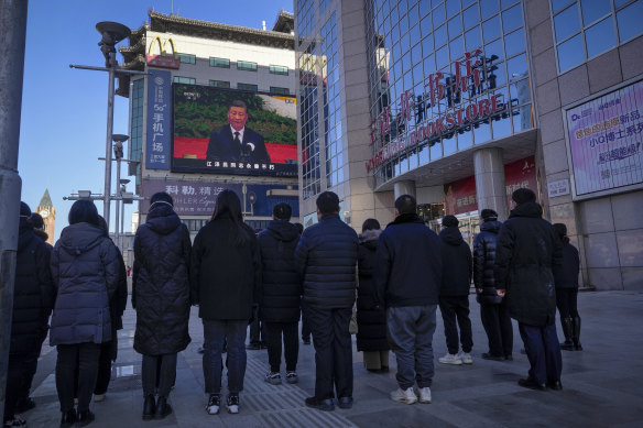 People watch a live broadcast of the memorial service for late former Chinese president Jiang Zemin. 