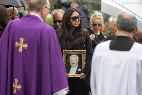 Alessia Cozzo holds her father’s portrait at his funeral in 2023.
