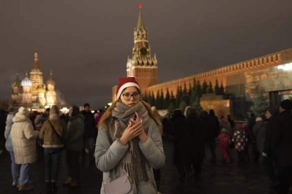 People walk in Red Square before its closure for celebrations on New Year’s Eve, with St Basil’s Cathedral, left, and the Spasskaya Tower, right, in Moscow.