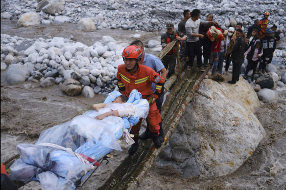 Rescuers transfer survivors across a river following an earthquake in Moxi in Luding County.