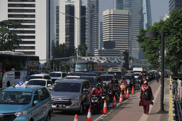 Motorcyclists wait alongside vehicles in traffic in the business district in Jakarta during a partial coronavirus lockdown.