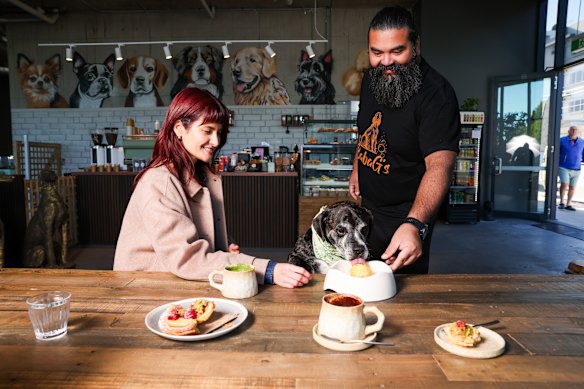 Baba G’s owner Sam Ayoub serves a pup-burger to customer Gus.