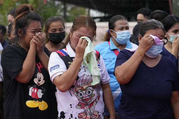 Relatives and friends mourn during a ceremony for those killed in the daycare centre attack at Uthai Sawan.