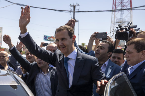 Syrian President Bashar Assad waves to his supporters at a polling station during the elections in the town of Douma in May 2021.