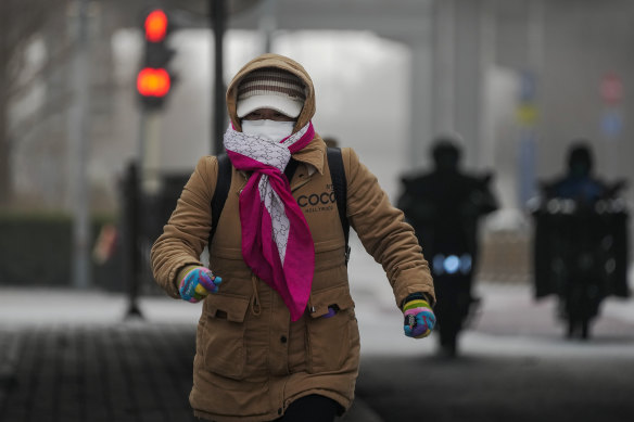 A woman runs across a street Beijing on Monday.