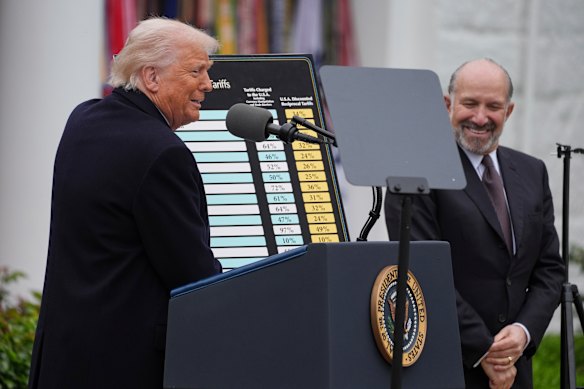 Donald Trump lovingly cuddled a big poster detailing the tariff vengeance he was about to unleash.