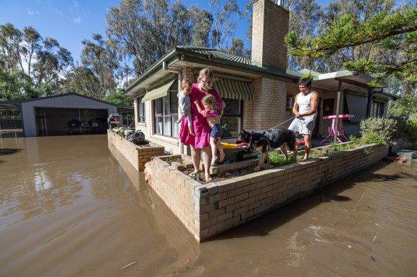 Aimee and Chris Lindrea, with children Kovie, 18 months, and Amelia, 3, check the floodwater surrounding their house in Rochester. 