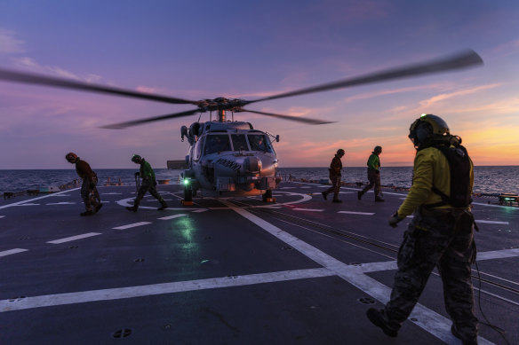 A Seahawk helicopter prepares to take off from the deck of HMAS Hobart.