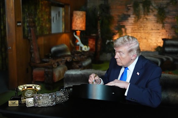Il presidente Donald Trump firma una replica di una chitarra di Elvis Presley nella Jungle Room di Graceland.