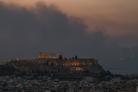 Smoke billows behind the Parthenon ancient temple on top of the Acropolis hill as a bushfire rages on the outskirts of Athens.