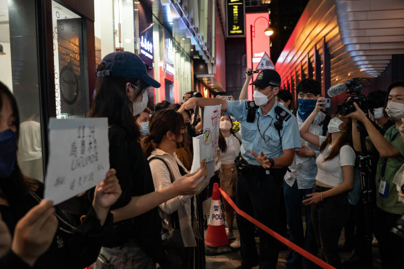 People hold signs at a COVID protest in Hong Kong.