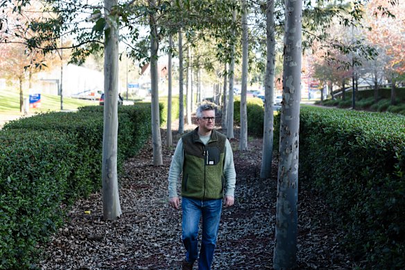 Western Sydney University Professor Sebastian Pfautsch walks down the middle of the trees on the median strip on Norwest Boulevarde in Norwest, an example of good urban design that can help to combat climate change and heat stress in Western Sydney. 