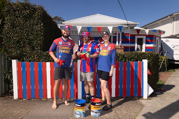 Newcastle Knights supporters Sam (left) and Tiegan (right) paint their house in Newcastle colours.