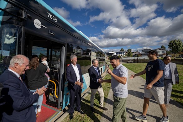 Transport for NSW co-ordinator-general Howard Collins, Transport Minister John Graham and Campbelltown MP Greg Warren welcome people aboard a new bus service in Macarthur Heights.