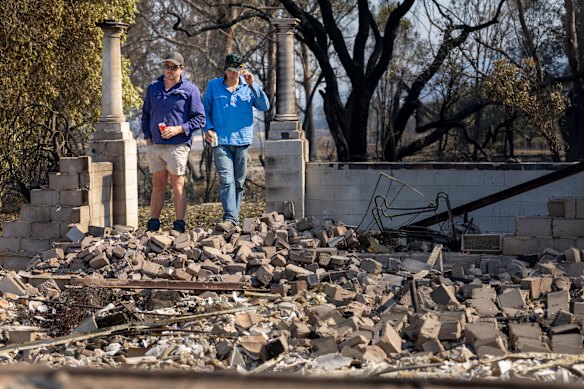 Relatives of Robbie Cumming inspect the ruins of his family home in Yark. 