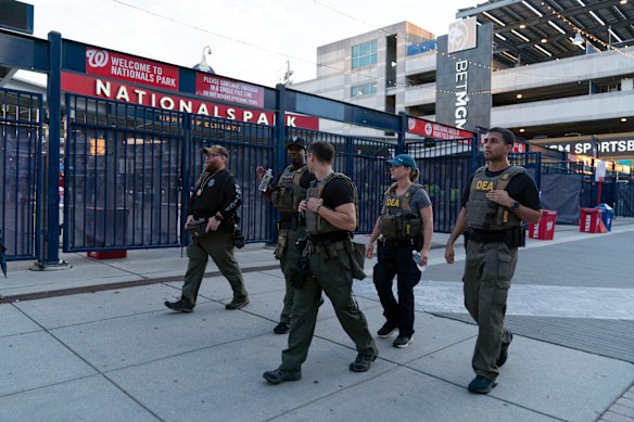 Os agentes da administração do resultado das drogas conversam no exterior do Nationals Park em um jogo de beisebol em Washington na quinta -feira.