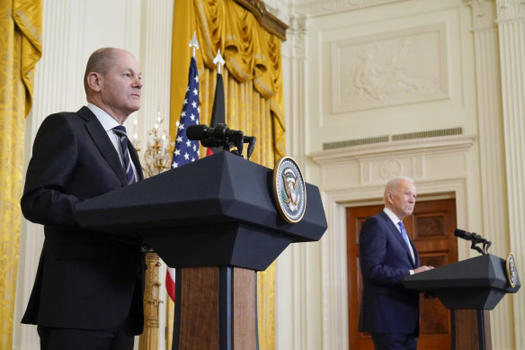 US President Joe Biden and German Chancellor Olaf Scholz listen to a question from a reporter during a news conference in the East Room of the White House, Monday in Washington.