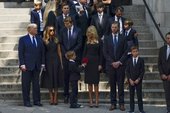 Former President Donald Trump, far left, stands with his family as the casket of Ivana Trump leaves following her funeral in New York.