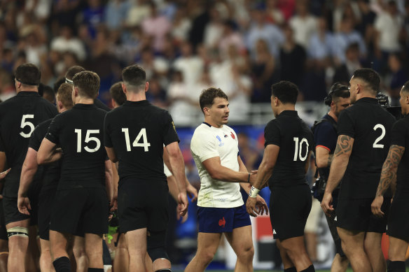 France’s Antoine Dupont, center, shakes hands with New Zealand players.