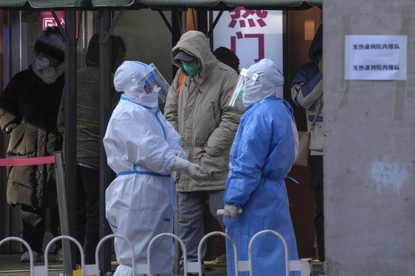 Medical workers in protective gear outside a COVID hospital in Beijing on Tuesday.