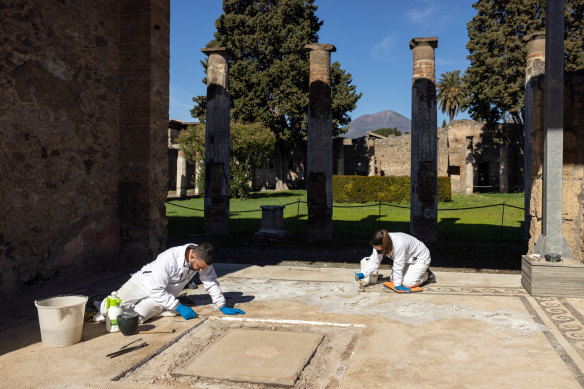 Restorers Aldo Guida, left, and Valentina Cifali at work on the mosaic floor of the House of the Faun at Pompeii.
