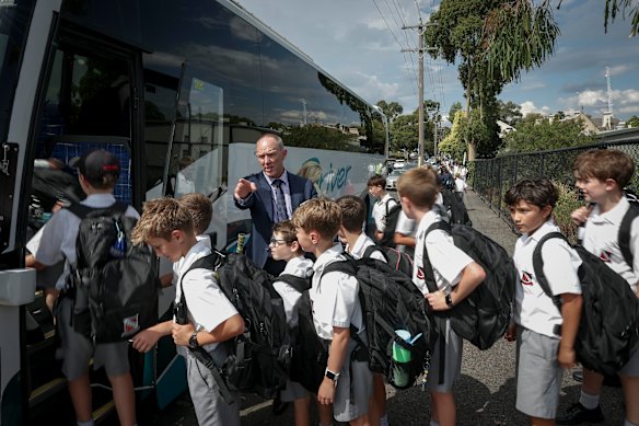 Brett Collison, director de la escuela primaria de Xavier College, con estudiantes que regresan a casa en autobuses escolares.