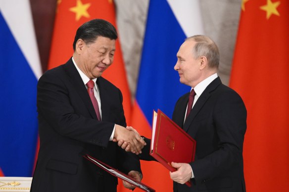 Russian President Vladimir Putin and Chinese President Xi Jinping exchange documents during a signing ceremony on Tuesday,