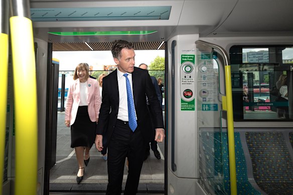 Premier Chris Minns walks onto a metro train at Bankstown station, followed by Summer Hill MP Jo Haylen.