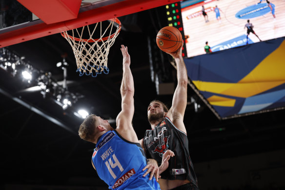 Melbourne United’s Jack White defends a dunk attempt by Illawarra’s Sam Froling.