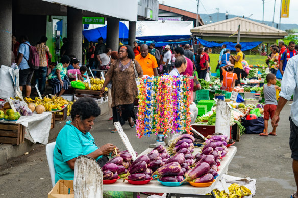 People go about their business on the streets of Suva on December 22. The government put the army on standby on Thursday.