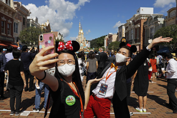 Visitors wear face masks at Hong Kong Disneyland last month.