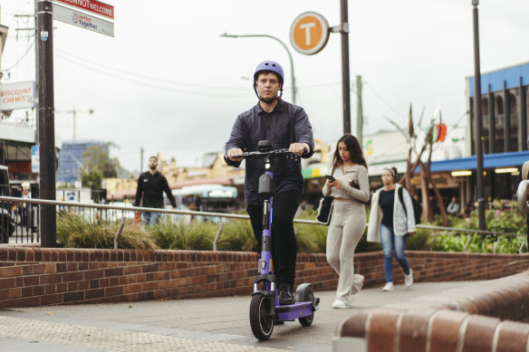 Inner West Greens councillor Dylan Griffiths on a Beam e-scooter outside Kogarah train station.