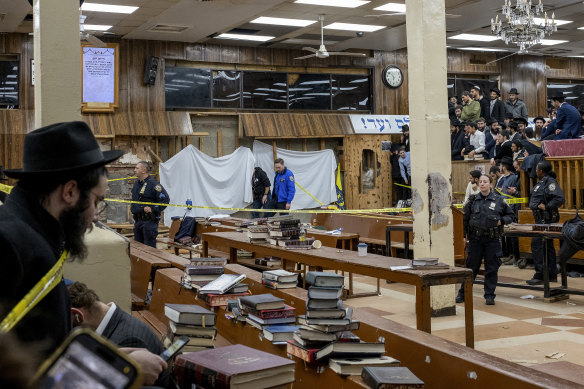 New York Police officers conceal the breach in the wall of the synagogue that led to a tunnel.