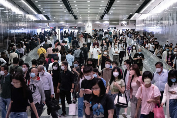 Residents walk in an MTR underground station in Hong Kong, one of the densest urban population centres in the world, with nearly 7000 people per square km.