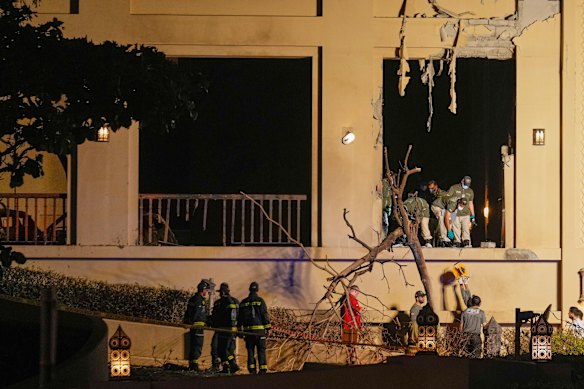 رجال الإطفاء وموظفو الإنقاذ يفحصون موقع انفجار في فندق فيرمونت ذا بالم في دبي يوم السبت.