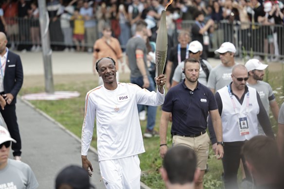US rapper Snoop Dogg holds the torch as part of the 2024 Paris Olympic Games Torch Relay, in Saint-Denis.