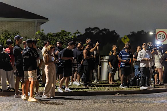 People gather on Brown Street in Bonnyrigg as police conduct an operation on a house in the wake of the mass shooting.